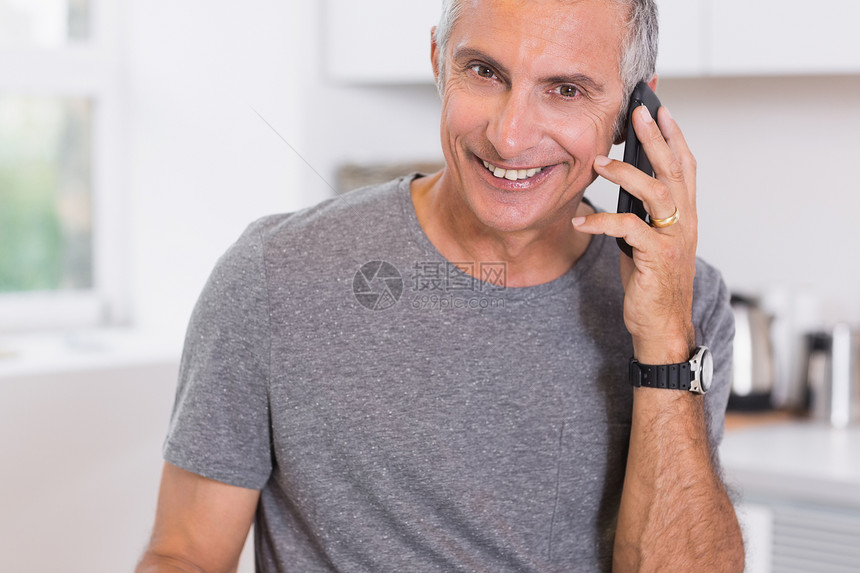 打电话时微笑的男人快乐柜台家庭男性退休房子沟通头发电话手机图片