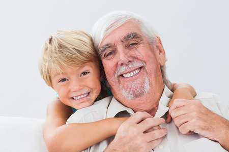 祖父和孙子金发女郎浅色男性客厅微笑家庭快乐头发男人金发背景图片