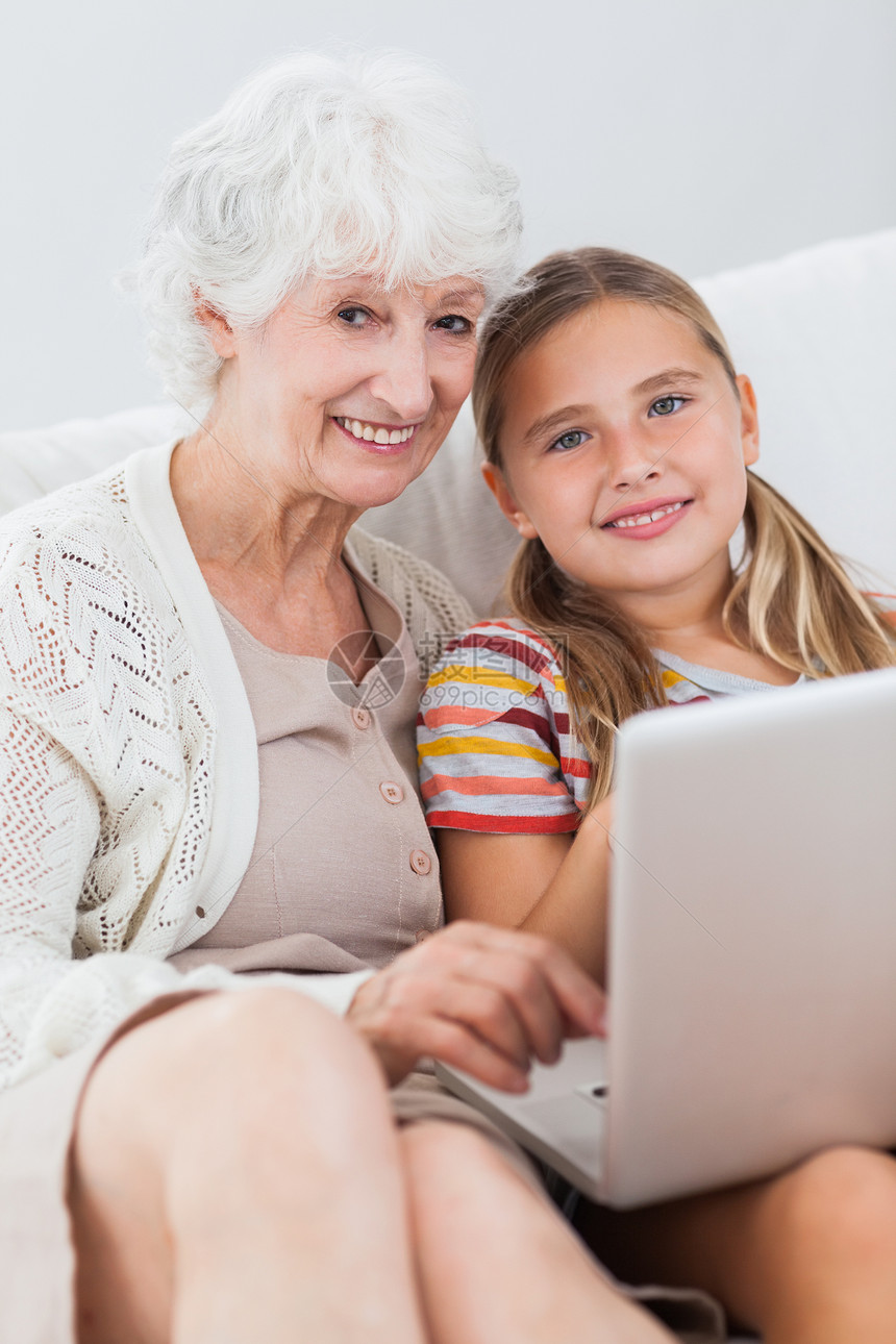 和奶奶一起用笔记本电脑的快乐女孩图片