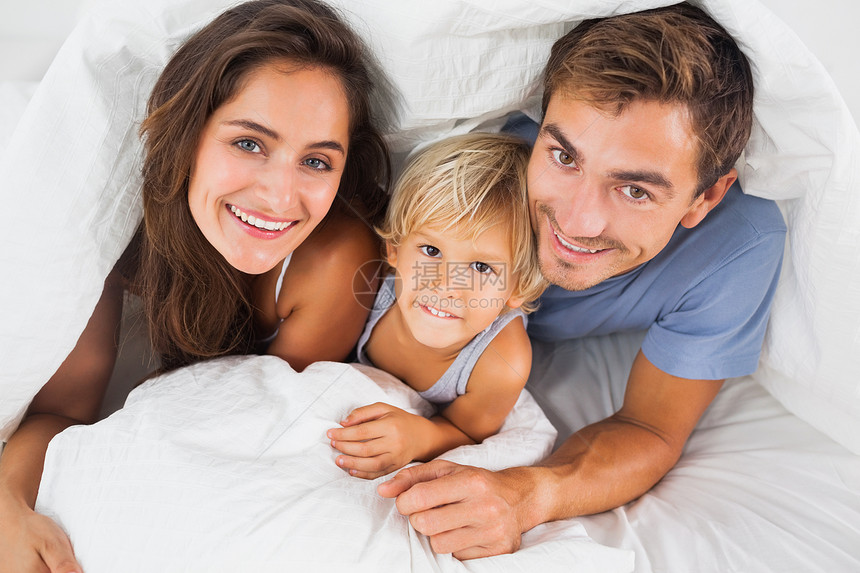 家人在床上的被子下微笑图片