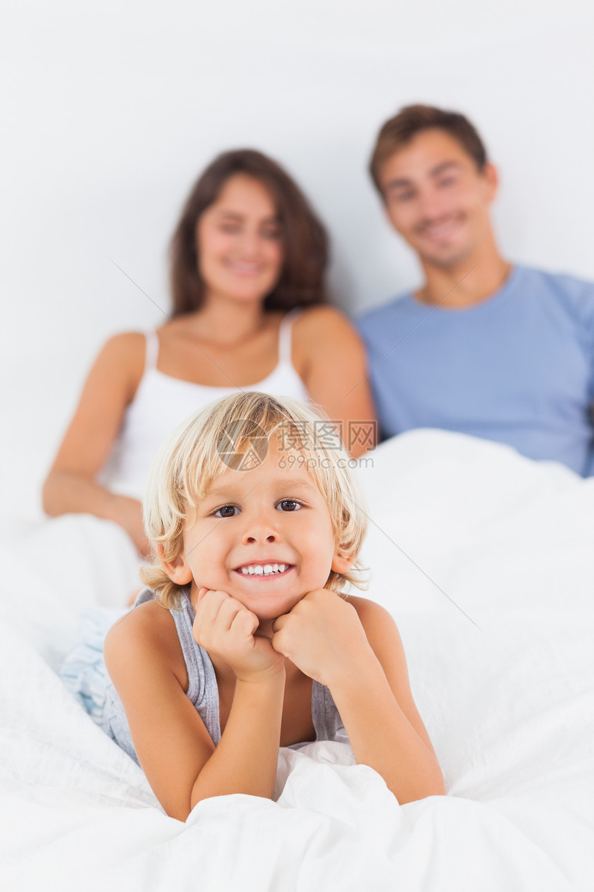 男孩躺在床上男性长发孩子枕头睡衣头发棕色家庭快乐金发图片