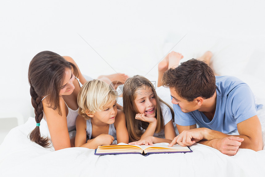 床上的家庭阅读书;图片