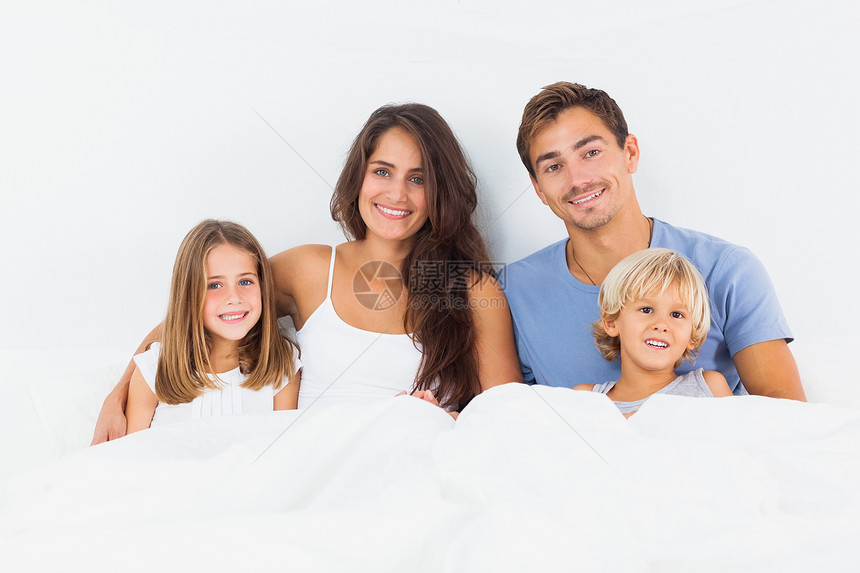 幸福的一家人一起躺在床上女孩感情父亲儿子孩子头发童年女儿快乐金发图片