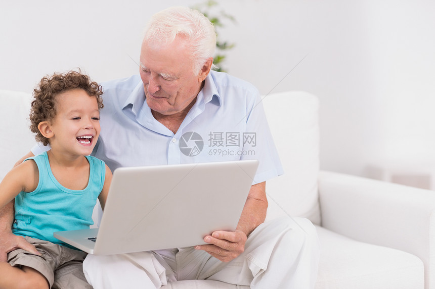 祖父和他的孙子在看笔记本电脑屏幕图片
