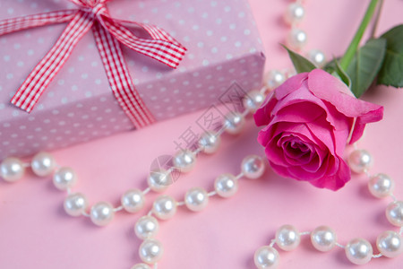 玫瑰粉红 有礼物和珍珠串背景图片