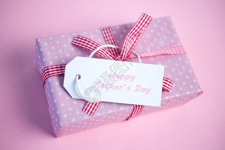 粉红礼物包装盒 带快乐母亲日贴标签背景图片