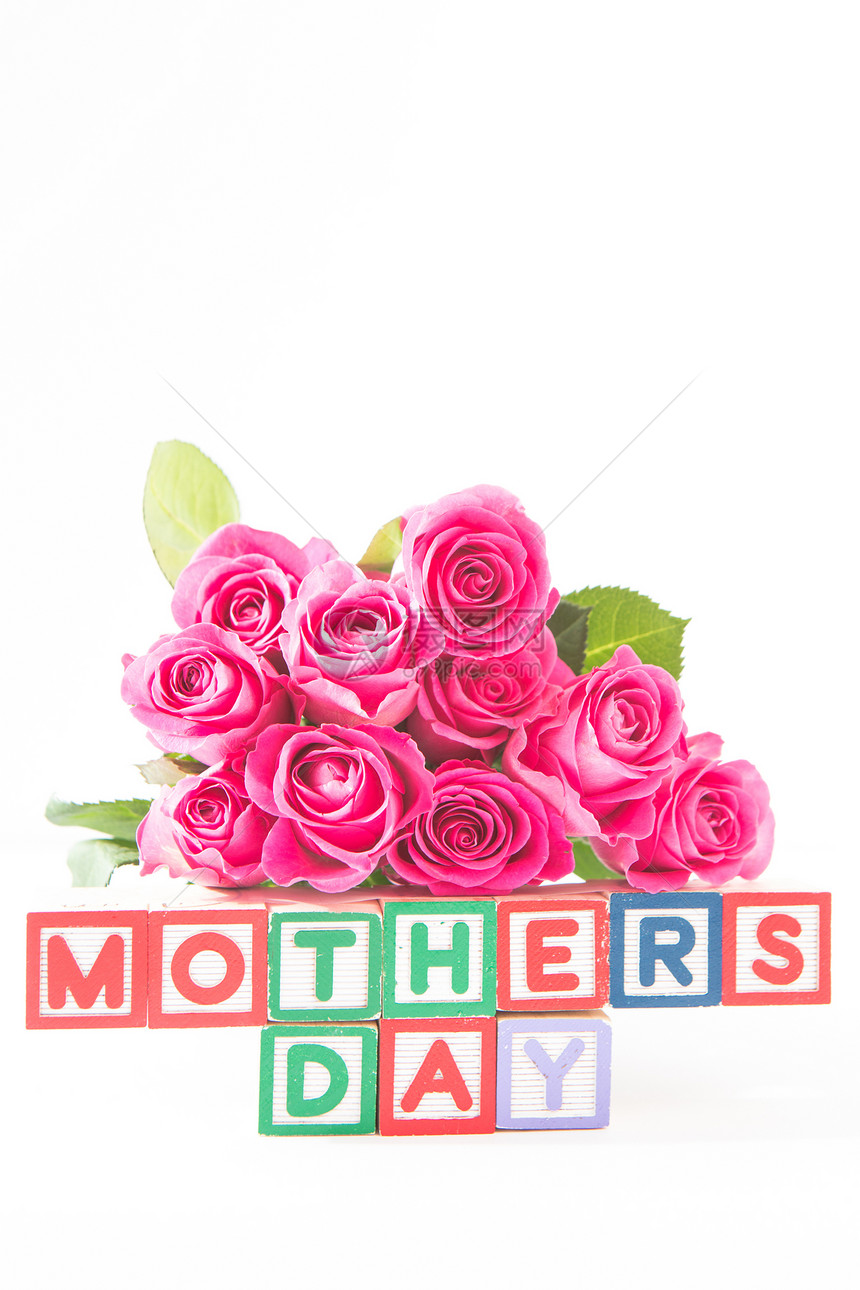粉红玫瑰的布束紧靠着不同颜色的木块 母亲节图片