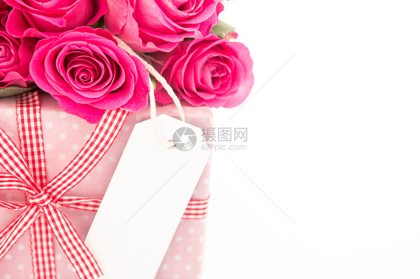 紧贴着一束粉红玫瑰的花束 旁边是一份粉红礼物 白底带一张空白卡图片