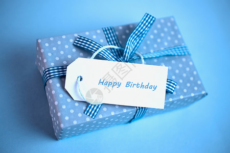 蓝色丝带标签蓝色的漂亮礼物 生日贺卡满蓝色背景背景