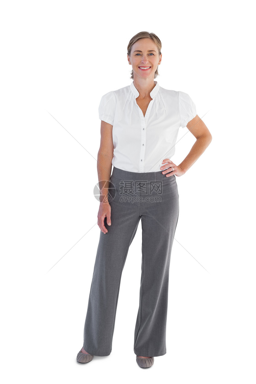 微笑的女商务人士站着手站在她的臀部上图片