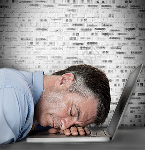 商务人士睡在笔记本电脑上桌子倾斜绘图计算机头发数字衬衫技术睡眠午睡背景图片