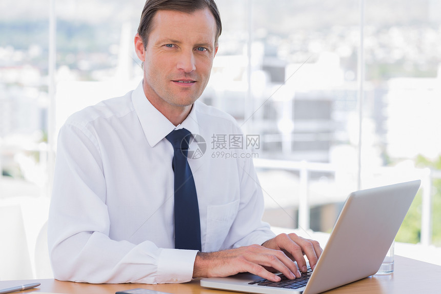 商务人士用笔记本电脑工作公司男人职场手机桌子专注领带男性商务人士图片