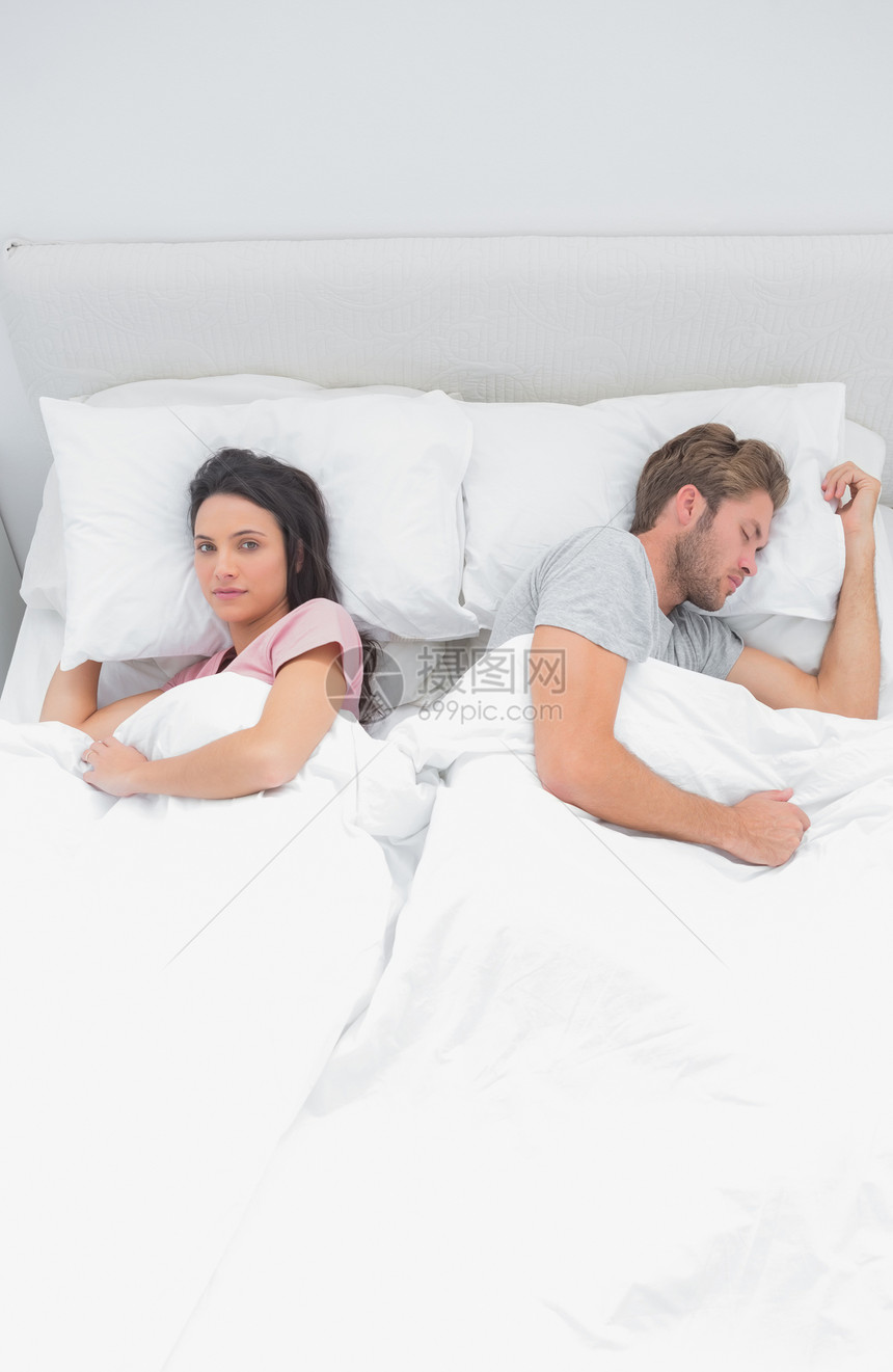 妇女看着相机 而她睡觉伴侣旁边的镜头图片