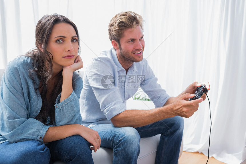 心烦女人的伴侣在玩电子游戏而生气图片