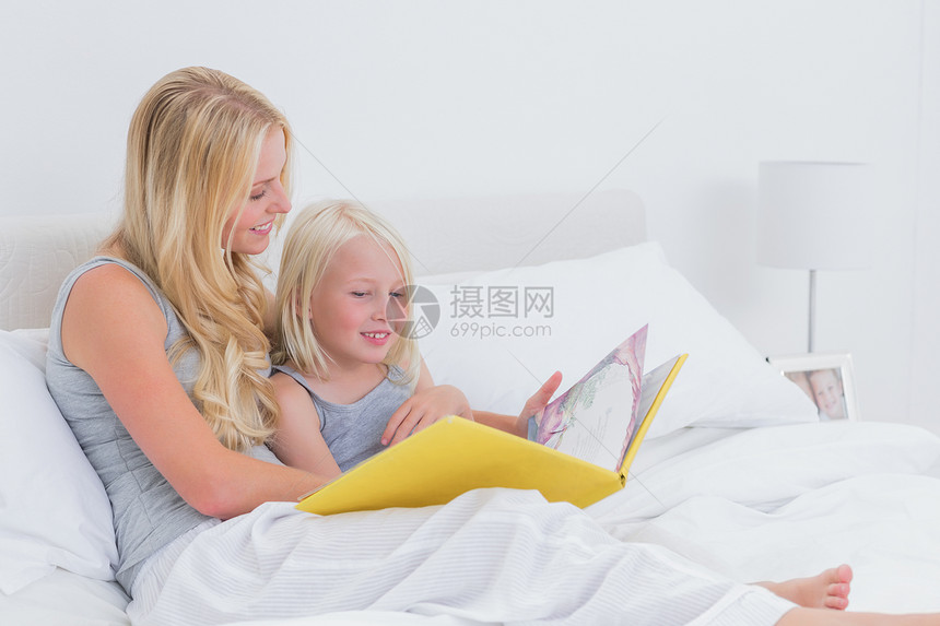 金发母亲在读一个故事给女儿听图片