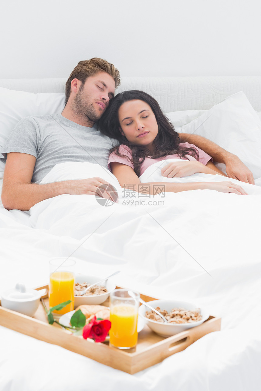 漂亮的夫妻睡在床上睡觉男性红玫瑰羽绒被微笑橙汁睡眠托盘女性快乐短发图片