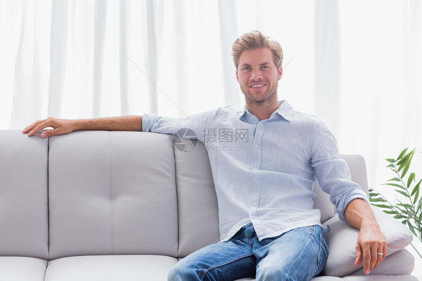 男人坐在客厅的沙发上图片