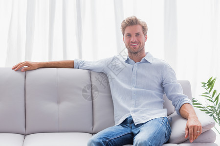 男人坐在客厅的沙发上背景图片