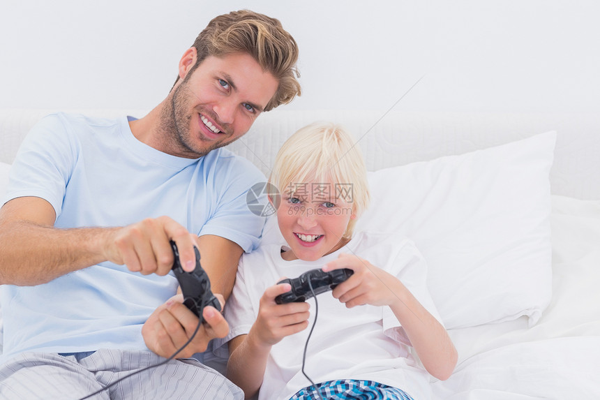 父亲和儿子在玩电子游戏时开心快乐图片