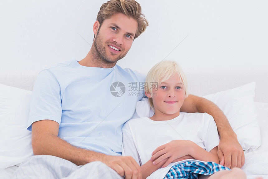 父亲和儿子的肖像家庭卧室男人浅色房子短发男生快乐金发枕头图片