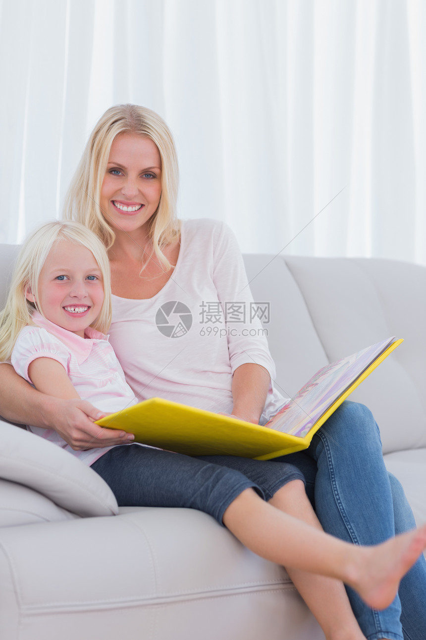 母亲和女儿在读一本书女性房子学习阅读微笑住所长发公寓家庭长椅图片