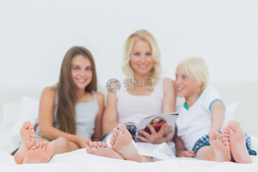 一家家庭阅读杂志的肖像图片
