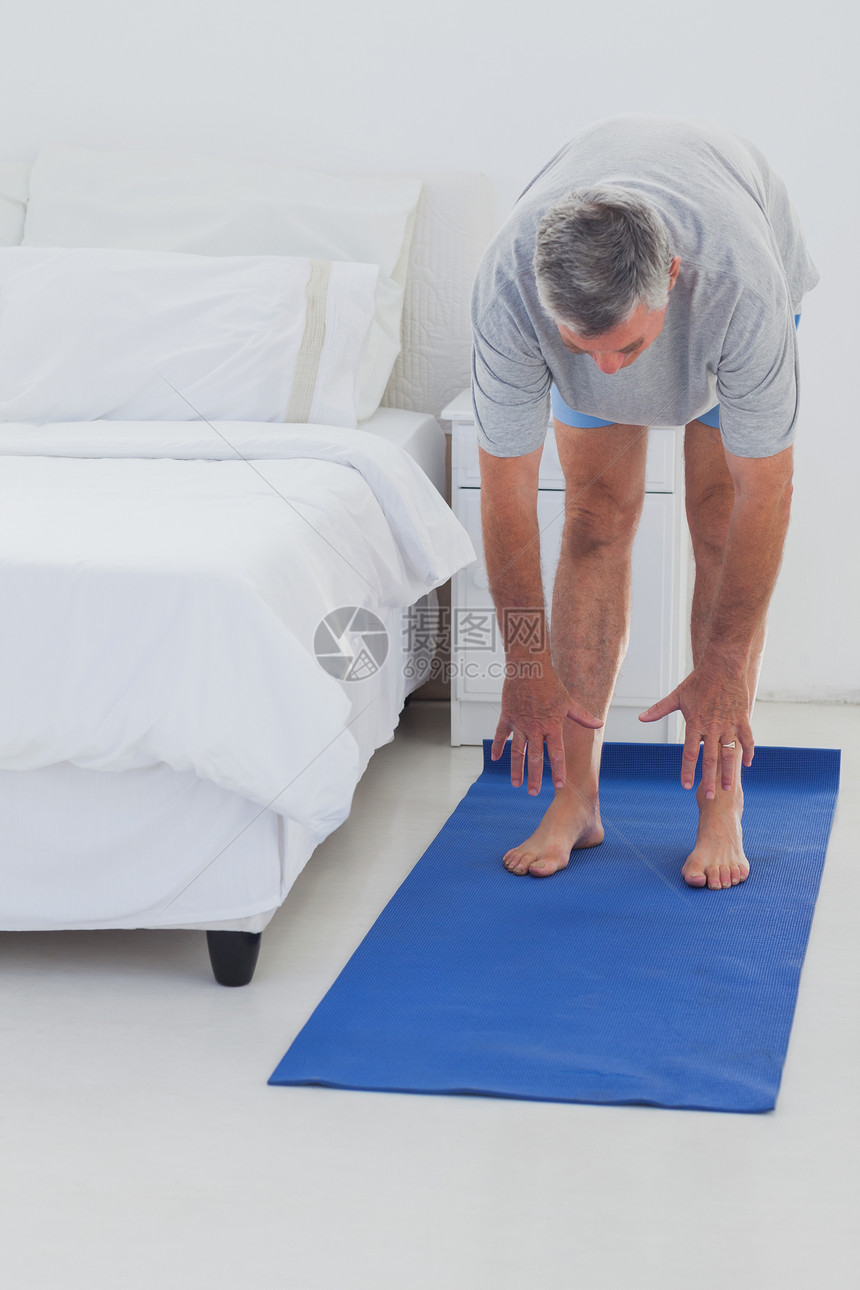人靠在垫子上伸展退休快乐锻炼枕头运动服岁月拉伸房子卧室家庭图片