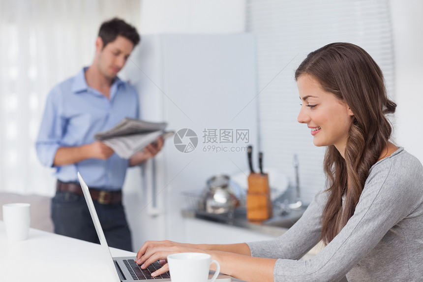 有吸引力的女人在厨房用笔记本电脑图片