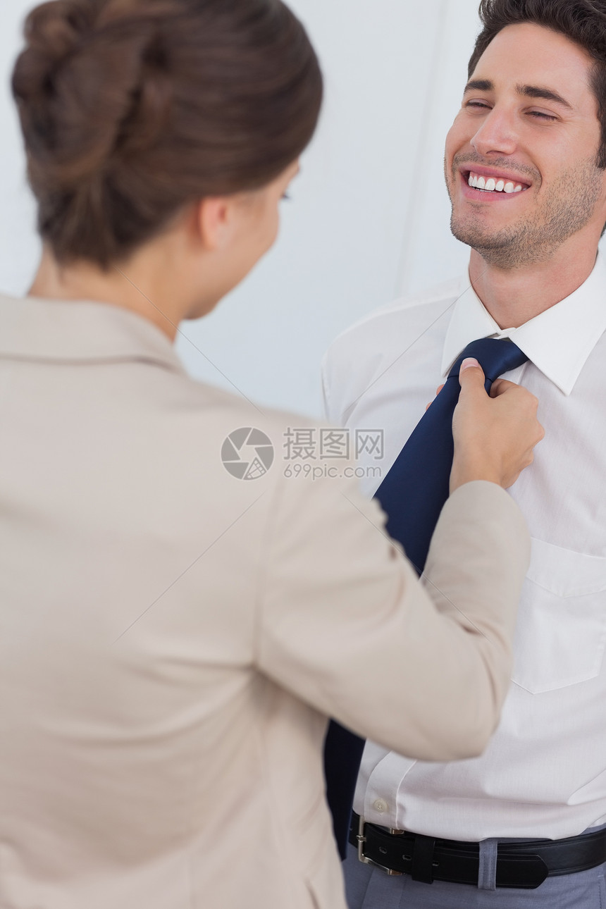 女人帮助她笑着的丈夫绑领带图片