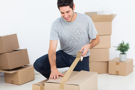 快乐的人包装一个盒子房间男性搬迁编带纸板盒纸盒男人公寓家庭住所背景图片