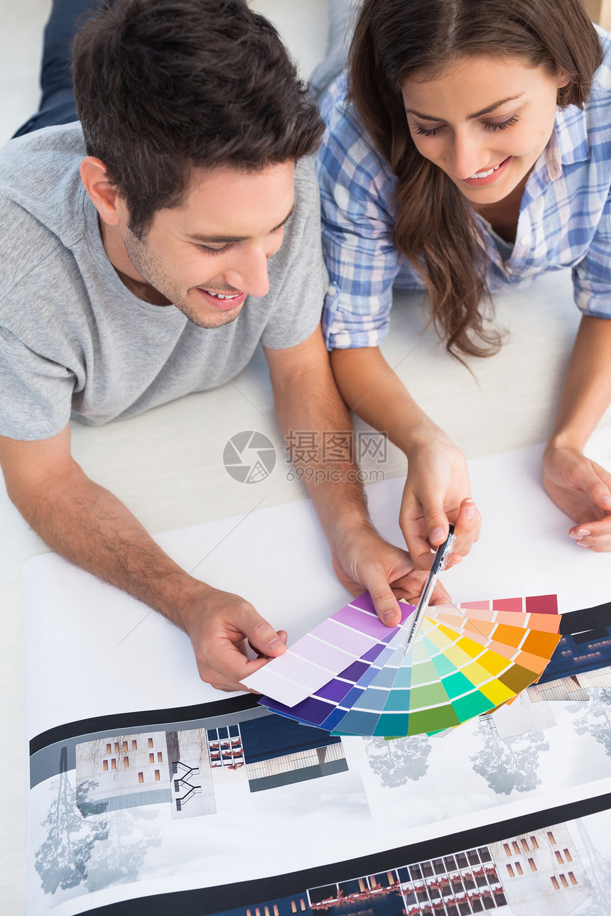 一对夫妇看彩色图表 装饰他们的房子图片