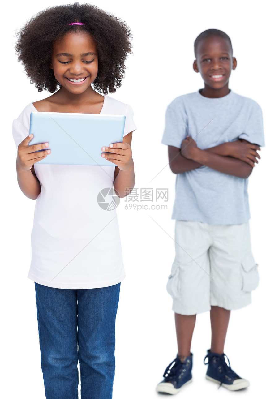 女孩在她哥哥身后使用平板电脑图片