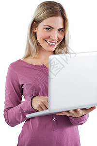 拿着笔记本电脑看镜头的女人长发技术头发金发女郎金发女士快乐女性浅色微笑背景图片