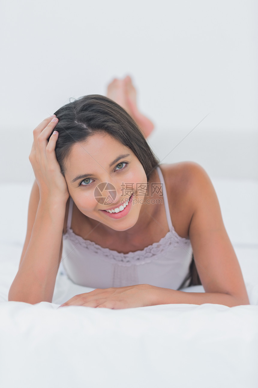 一个有吸引力的女人躺在床上放松放松的肖像图片