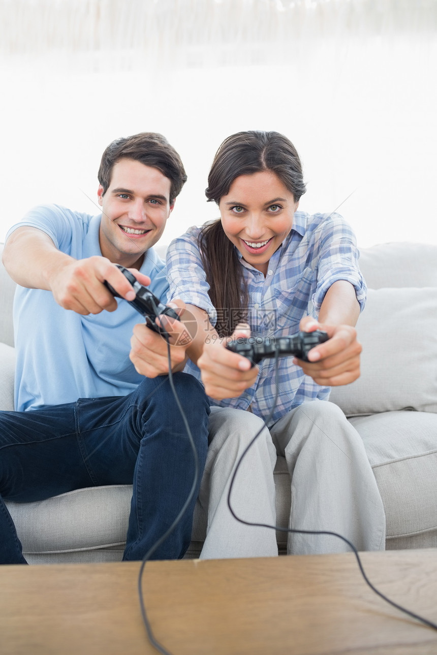 一对夫妇在沙发上玩电子游戏的肖像图片