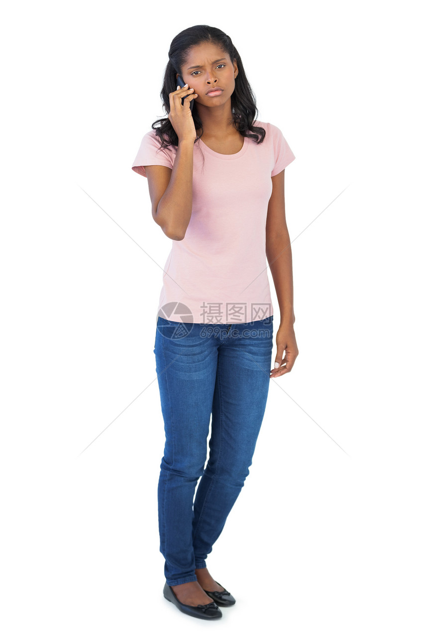 严重女人用她的手机打来电话讨论呼唤互动牛仔布女士女性黑发牛仔裤长发技术图片