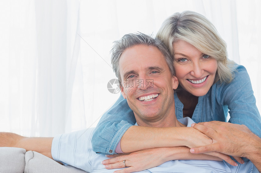 情侣对着镜头微笑快乐金发住所女士感情女性夫妻房子公寓亲密感图片