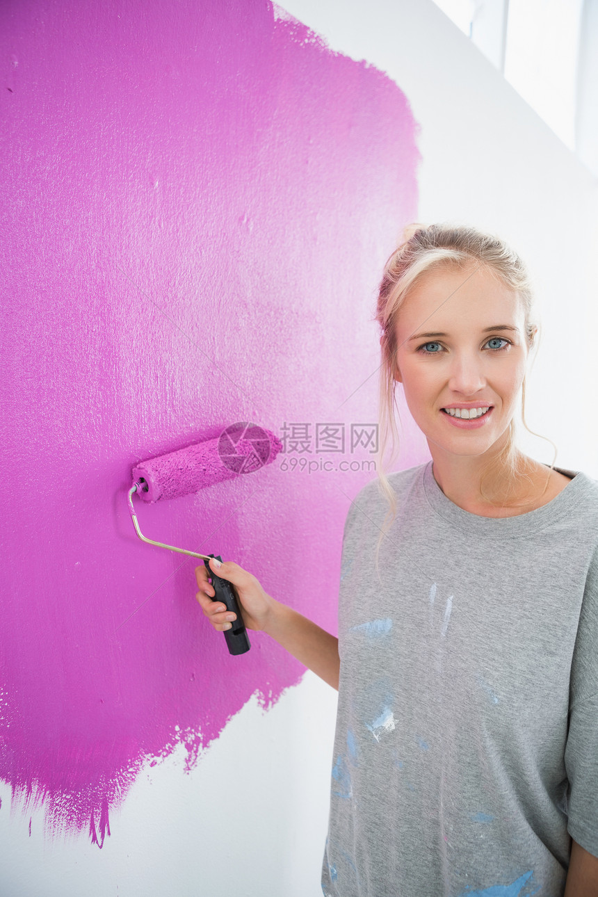 美丽的女人画着她的墙壁粉红色图片