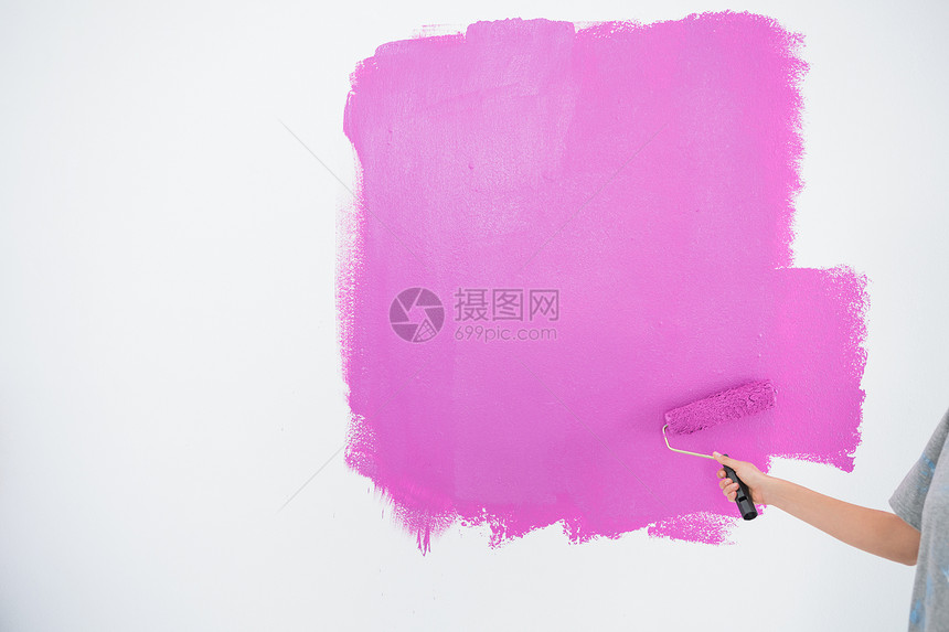 女人用粉红色的画着她的墙壁图片