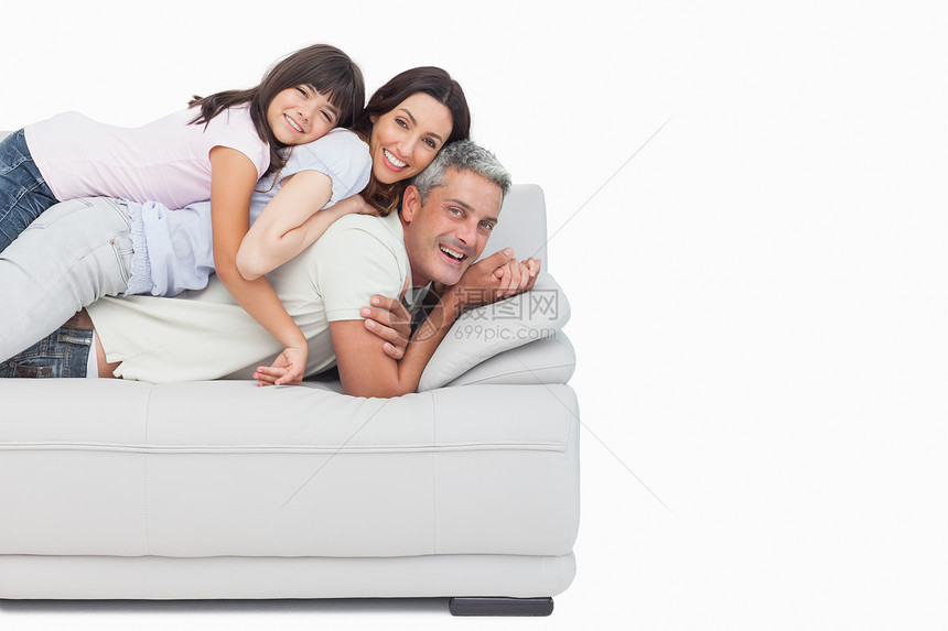躺在沙发上父母身边的微笑小女孩图片