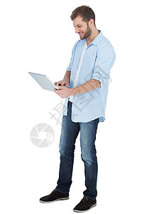 使用笔记本电脑的伤者技术牛仔裤微笑衬衫男性快乐牛仔布男人背景图片