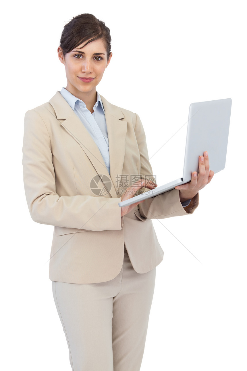 持有手提笔记本电脑的严重年轻女商务人士图片