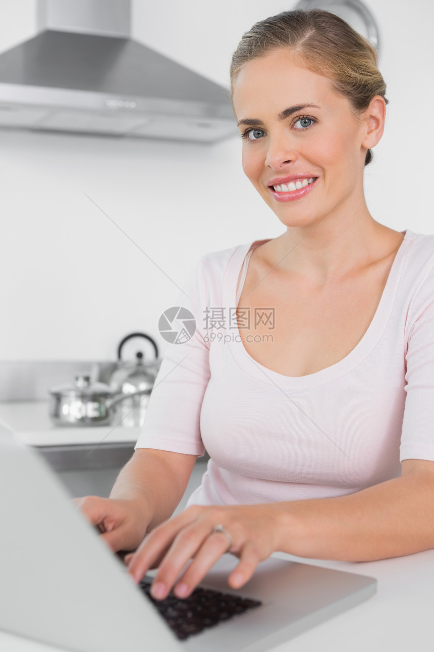 使用笔记本电脑的微笑妇女技术柜台住所女性家庭公寓快乐房子女士闲暇图片