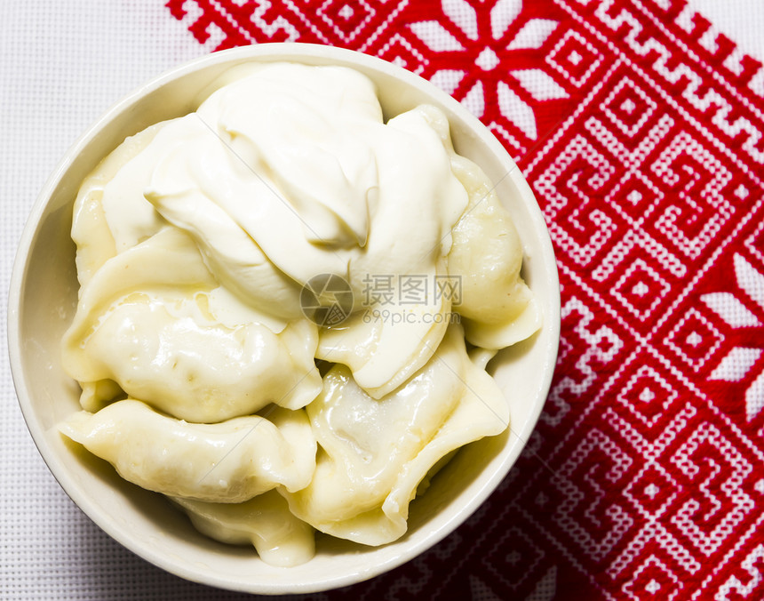 乌克兰刺绣毛巾上涂着酸奶油的胡包子乡村绣花餐巾盘子红色美食面团午餐土豆白色图片