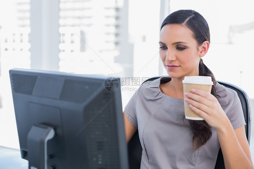拥有咖啡和工作的有吸引力的女商务人士图片