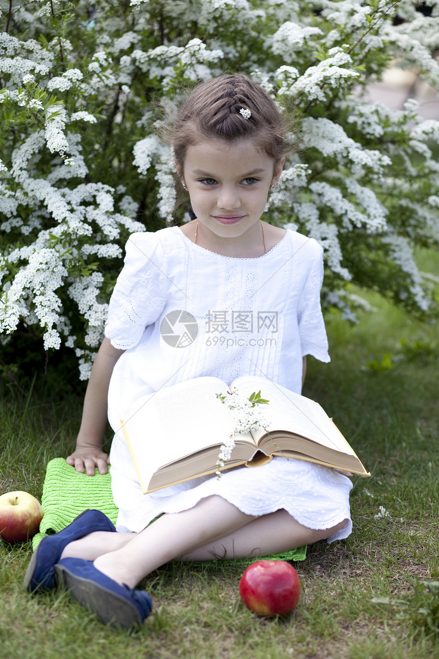 春花中美丽的小女孩的肖像裙子女学生黑发青少年衬套阅读冒充童年小姑娘水果图片