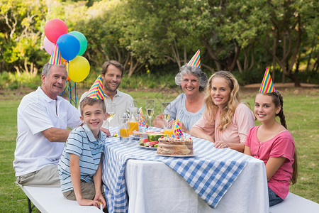 家人在生日派对上对着镜头微笑高清图片
