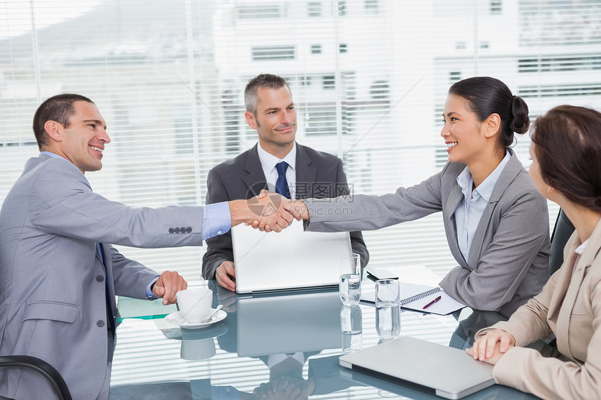 商业界人士握手微笑生意人协议笔记本会议同事男人团队女士电脑合作图片