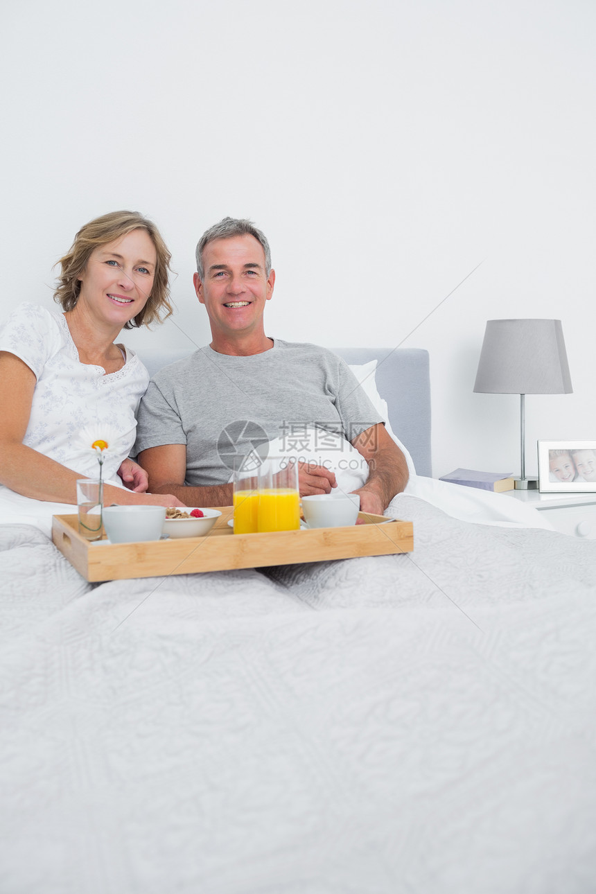 中年夫妇一起在床上吃早饭图片