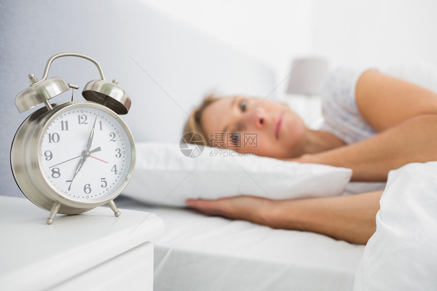 金发女人睡在床上 而她的警钟显示 早期图片